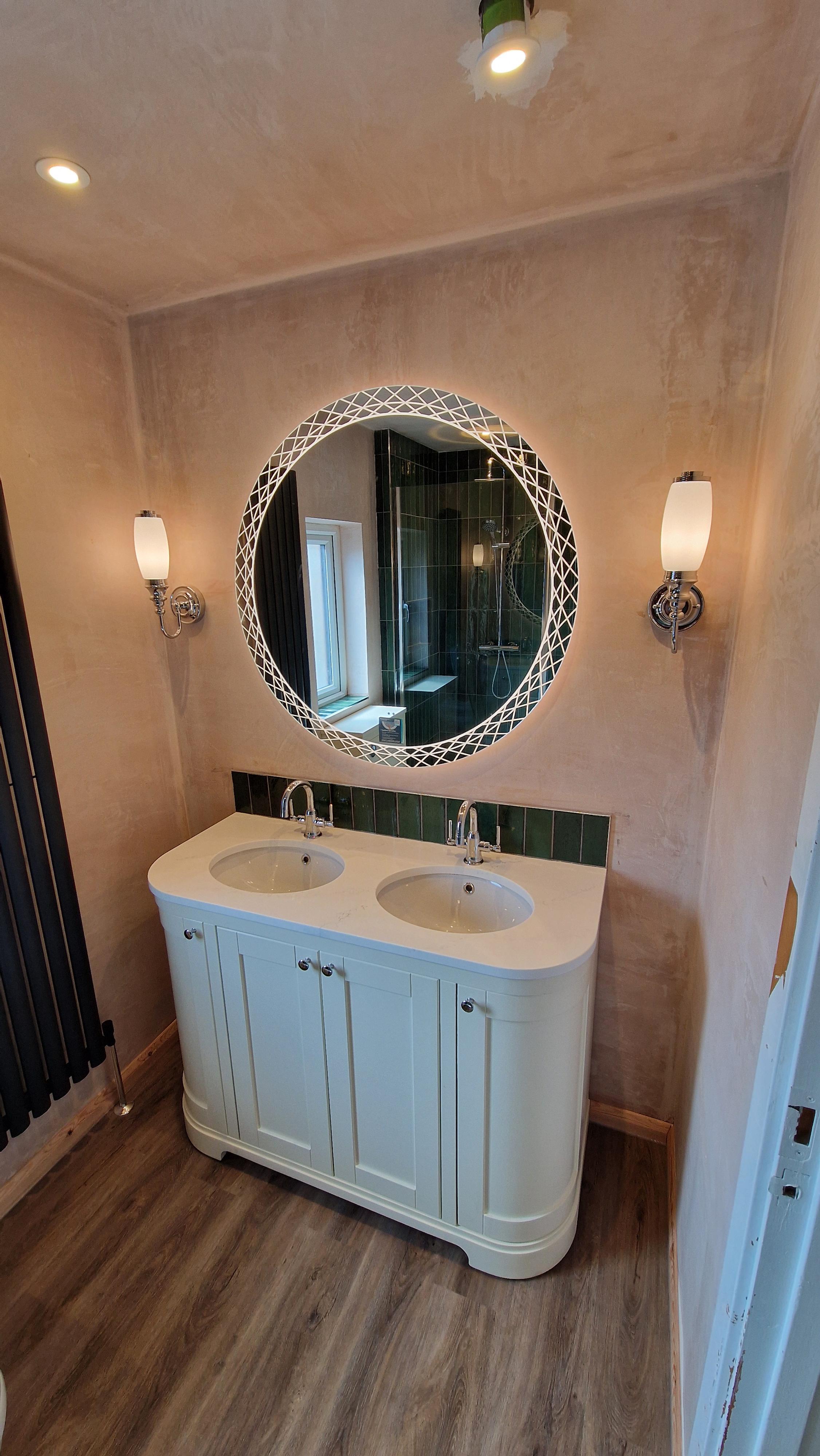 Twin-basin painted vanity under a round illuminated mirror